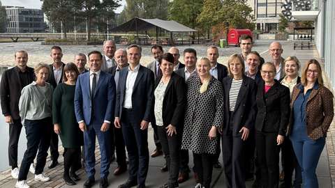 Group photo of people, with an empty yard in the background.
