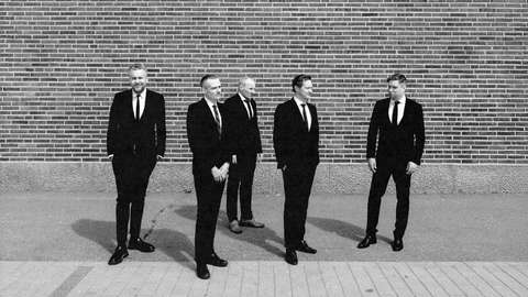 The Five Corners Quintetin jäsenet mustissa puvuissa Senaatintorin portaiden edessä.