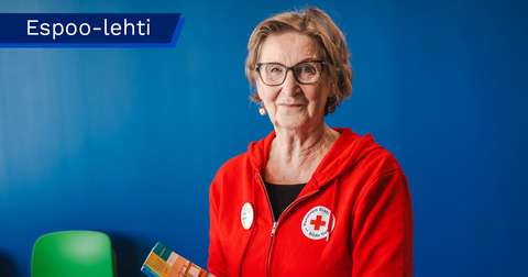 Paula Mäntysalo ser leende mot kameran och har på sig en huvtröja med Röda korsets logo.