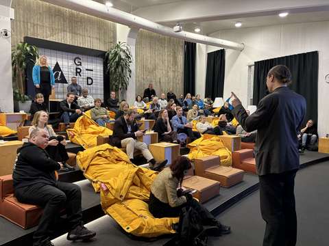 Ihmisiä tapahtumassa kuuntelemassa esitystä.