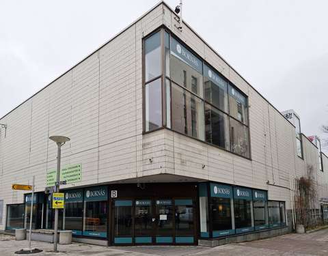 Kaksikerroksinen vaalea rakennus.