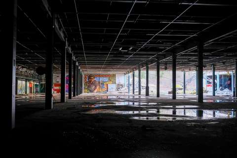 Märkä ja pimeä, osittain purettu hallirakennus. Peräseinällä Keran Halleilta tuttu muraali.