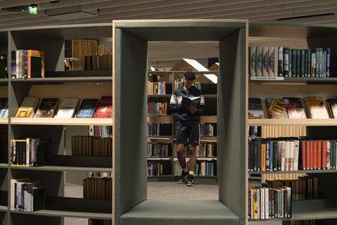 Kirjahylly ja asiakas tutkimassa kirjoja.