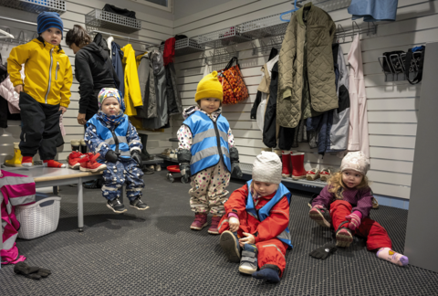 Lapsia päiväkodin eteisessä pukeutumassa.