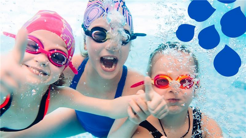 Kolme iloista lasta uimassa veden alla.
