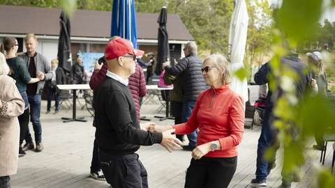 Kuvassa ihmiset tanssivat pareittain ulkona.