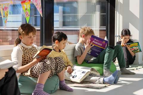 Niittykummun Montessori-luokan lapsia syventyneinä kirjoihinsa