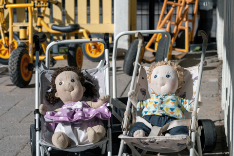 Två dockvagnar, med en docka i varje.