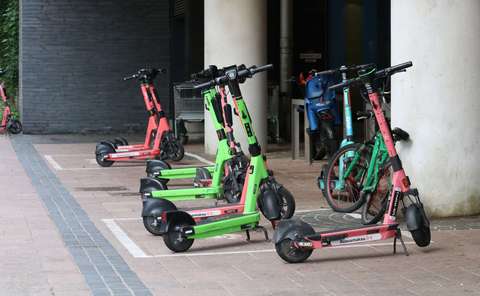 Sähköpotkulautoja pysäköityinä niille tarkoitettuihin pysäköintiruutuihin.