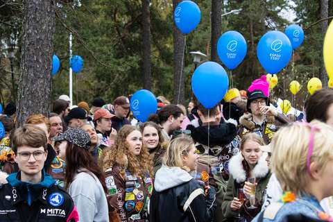 Teekkareita juhlimassa vappua värikkäissä haalareissa ja ilmapallot käsissä.