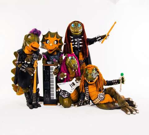 dinosauruksiksi pukeutuneet muusikot.