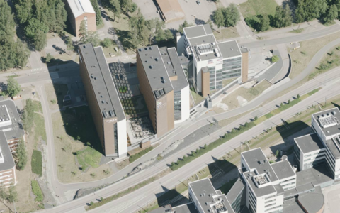Ilmakuvassa näkyy kolme pitkulaista ruskeavalkoista toimistorakennusta, jotka yhdistyvät toisiinsa matalalla jalustaosalla. Niitä ympäröi nurmi yksittäisine puuistutuksineen ja liikenneväylät.
