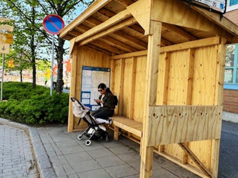 Kuvassa on puusta valmistettu väliaikainen bussipysäkki.