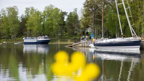 Kuvassa saaristovene lähestyy laituria satamassa.