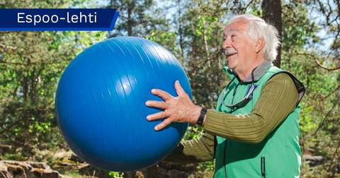 Harri Turpeinen is holding a large exercise ball in his hands. The photo was taken outdoors.
