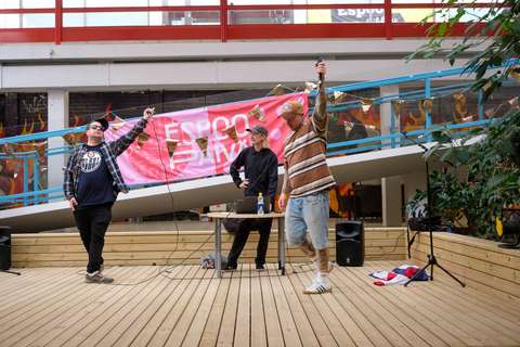 The performers raise their microphones. The background features festive buntings and a banner for Espoo Day.