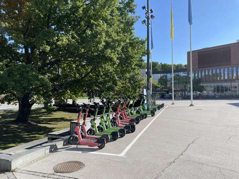 Electric scooters parked in parking spaces.