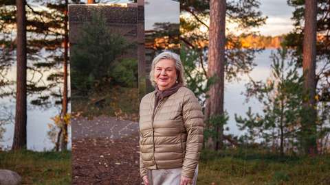 Gunvor Kronman katsoo kameraan taustallaan merimaisemaa ja peilitaideteos.