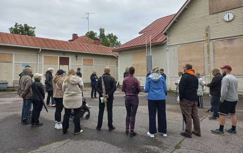 Kävelylle osallistujia keskustelemassa vanhan Kungsgårdsskolanin edessä.