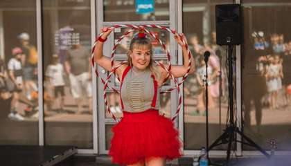 Esiintyjä pitelemässä käsissään hula-hula-vanteita ja hymyilemässä yleisölle.