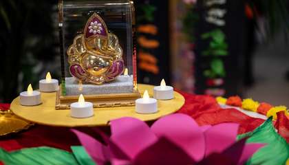 Kukkia ja kynttilöitä Ganesha-asetelman ympärillä. 