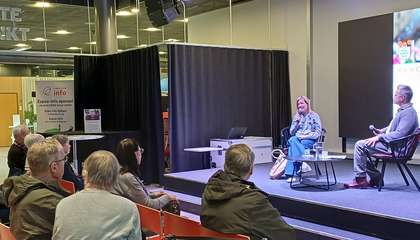 Karin Collins och intervjuaren Larson Österberg på scen i Sellos bibliotek. Publiken sitter i förgrunden.