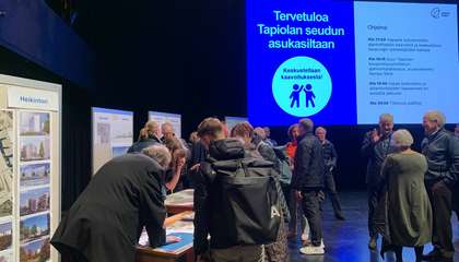 Ihmisiä keskustelemassa erilaisilla ständipisteillä.