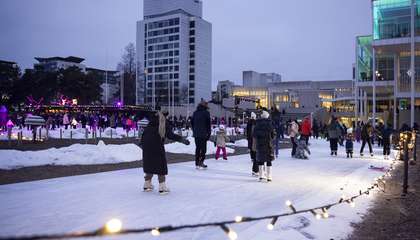 Kuvassa näkyy Tapiolan jääpuutarha. Jäällä luistelee joukko ihmisiä.